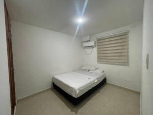 Habitación blanca pequeña con cama. en Vivamar Oasis Cartagena, en Cartagena de Indias