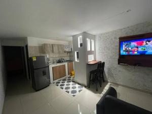 una pequeña cocina con TV en la pared en Vivamar Oasis Cartagena, en Cartagena de Indias