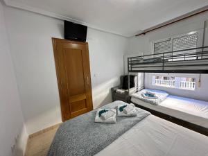 ein Schlafzimmer mit zwei Etagenbetten mit Handtüchern darauf in der Unterkunft Homely Apartments Vitoria in Torrevieja + 25 Fotos
