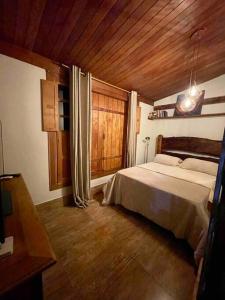 um quarto com uma cama e um tecto de madeira em Casa Portal Sagrado Matutu- Aiuruoca MG em Aiuruoca