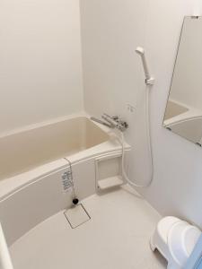 a white bathroom with a shower and a sink at Tokyo Kamakura House in Tokyo