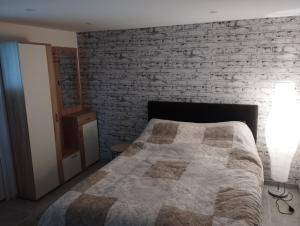 1 dormitorio con cama y pared de ladrillo en Studio, en Haguenau