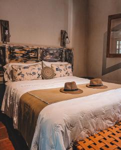 two hats are sitting on a bed in a bedroom at Finca La Saucina Casa de Campo in Tunuyán