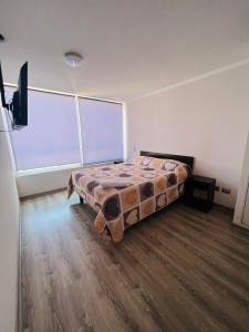 1 dormitorio con cama y ventana grande en Departamento Vista al Mar, en Iquique