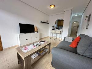 ein Wohnzimmer mit Sofa und Tisch in der Unterkunft Homely Apartments Vitoria in Torrevieja