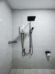 una doccia in bagno con tubo nero di L.C. Apartments a Nathon Bay