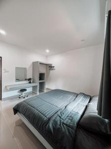 a bedroom with a large bed and a desk at L.C. Apartments in Nathon Bay
