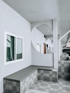 a room with a bench and a circular mirror at L.C. Apartments in Amphoe Koksamui