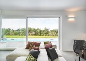 a living room with a couch and a large window at Villa Angelina in Lazise
