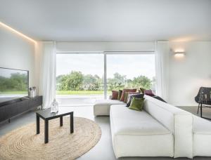 a living room with white furniture and a large window at Villa Angelina in Lazise