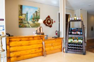 Habitación con tocador de madera y estantería de botellas de vino. en Oak Tree Hotel, en Arcadia