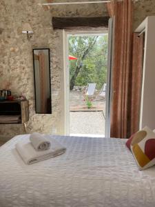 a bedroom with a bed and a door to a patio at La Parenthèse du Var - Chambre d'hôtes petits déjeuners inclus et terrasse ombragée in Saint Antonin du Var +54 photos