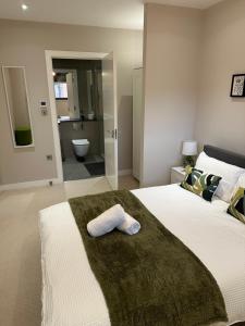 a bedroom with a large bed with a towel on it at Richardson Deluxe Apartments (2-Bed) in London