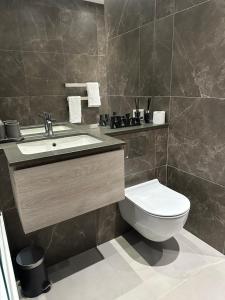 a bathroom with a toilet and a sink at Richardson Deluxe Apartments (2-Bed) in London