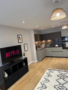 a living room with a television and a kitchen at Richardson Deluxe Apartments (2-Bed) in London