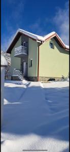 ein Haus mit Schnee davor in der Unterkunft Vila Mishela in Berovo