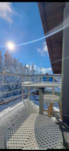 a table and chairs on a balcony with snow at Vila Mishela in Berovo