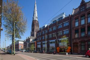 uma torre de igreja no meio de uma rua da cidade em easyHotel The Hague City Centre em Haia