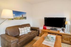 sala de estar con sofá y TV en Windrose, en Wilhelmshaven