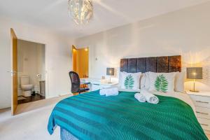 a bedroom with a large green bed with white pillows at Cozy appt in Colindale in Colindale