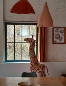 a statue of a giraffe on a table next to a window at Holiday Loft 58 in Arbois