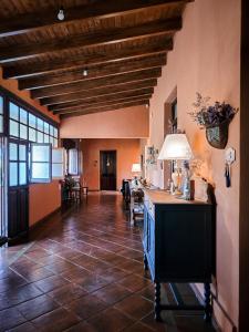 Habitación grande con suelo de baldosa y mesa con lámpara. en Finca La Saucina Casa de Campo en Tunuyán