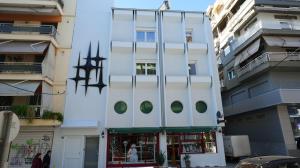 a white building with green windows in a city at Sidus Condos in Veria