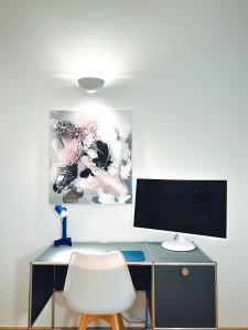 a desk with a computer monitor and a white chair at The Gallery in Munich