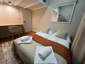 1 dormitorio con 1 cama con toallas en Elegancki Apartament Polonia Residence z widokiem na centrum Łodzi i prywatnym parkingiem, en Łódź