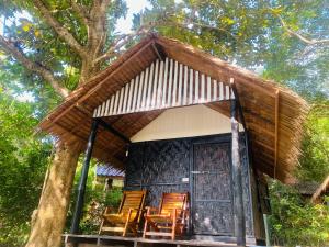 a group of chairs sitting in front of a house at Banana Resort in Ko Phayam