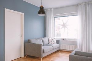 a living room with a couch and a window at Nordic Design Apartment City Center in Rovaniemi