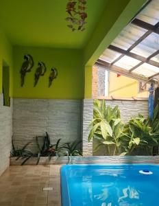 Cantinho feliz de Muriqui/ Casa verde com piscina privativa!!! في مانغاراتيبا: مسبح في غرفة فيها نباتات على الحائط