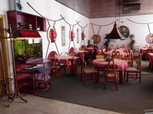 a restaurant with pink tables and chairs and a fish tank at Penzion Velke Darko in Škrdlovice