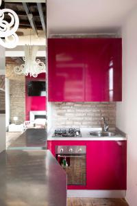 a kitchen with red cabinets and a sink at Monti apartment BDB in Rome