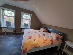 a bedroom with a bed and two windows at de Bloemenhof in Ouddorp
