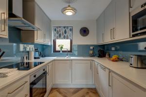 Una cocina con gabinetes blancos y un fregadero y una ventana. en Spires View, en Oxford 9 fotos más