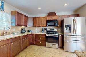 a kitchen with wooden cabinets and stainless steel appliances at Keepin' it Reel in Pensacola Beach