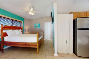a bedroom with a bed and a refrigerator at Keepin' it Reel in Pensacola Beach