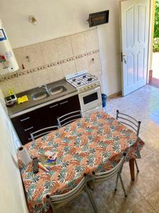 Aires de las Sierras في فيلا كارلوس باز: مطبخ مع طاولة وموقد فرن علوي