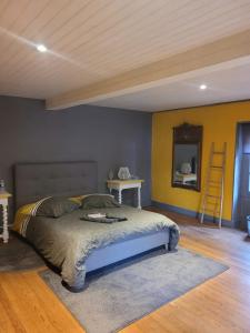 a bedroom with a bed and two tables and a mirror at Petite maison dans les bois 