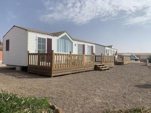 a row of tiny homes on a gravel lot at Camping wassay beach in Sidi Ouassay