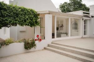 ein weißes Haus mit Glastüren und Treppen in der Unterkunft La Sosta in Swellendam