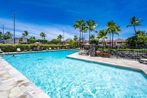 a swimming pool at a resort with palm trees at CheCaHale: Gorgeous Top Floor Corner With AC in Kailua-Kona