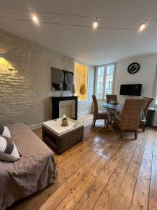 a living room with a couch and a table at L'escale Niortaise - Centre-ville - 10mn Gare - WIFI - Netflix in Niort