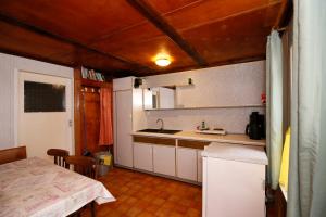 uma cozinha com um lavatório e uma mesa num quarto em Bungalow MEER ODER WENIGER direkt am Strand em Dranske