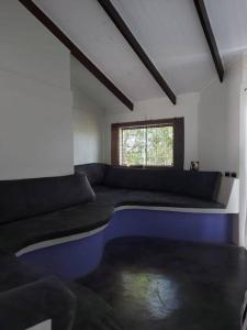 um quarto com um sofá grande e uma janela em Casa Ísis- Chapada dos Veadeiros em Alto Paraíso de Goiás