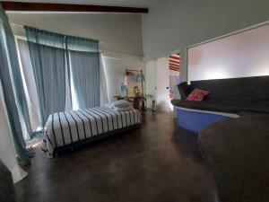 um quarto com uma cama e um sofá num quarto em Casa Ísis- Chapada dos Veadeiros em Alto Paraíso de Goiás