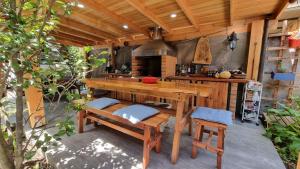 una cocina al aire libre con mesa de madera y bancos en Blue House Cabaña - Departamento - Habitación en Pucón