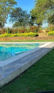 une piscine d'eau bleue et un trottoir dans l'établissement Elegante casa campestre con Piscina, à Valledupar