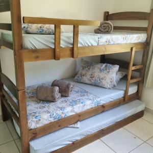 a bunk bed with pillows on the bottom bunk at Casa no Sítio in Penha